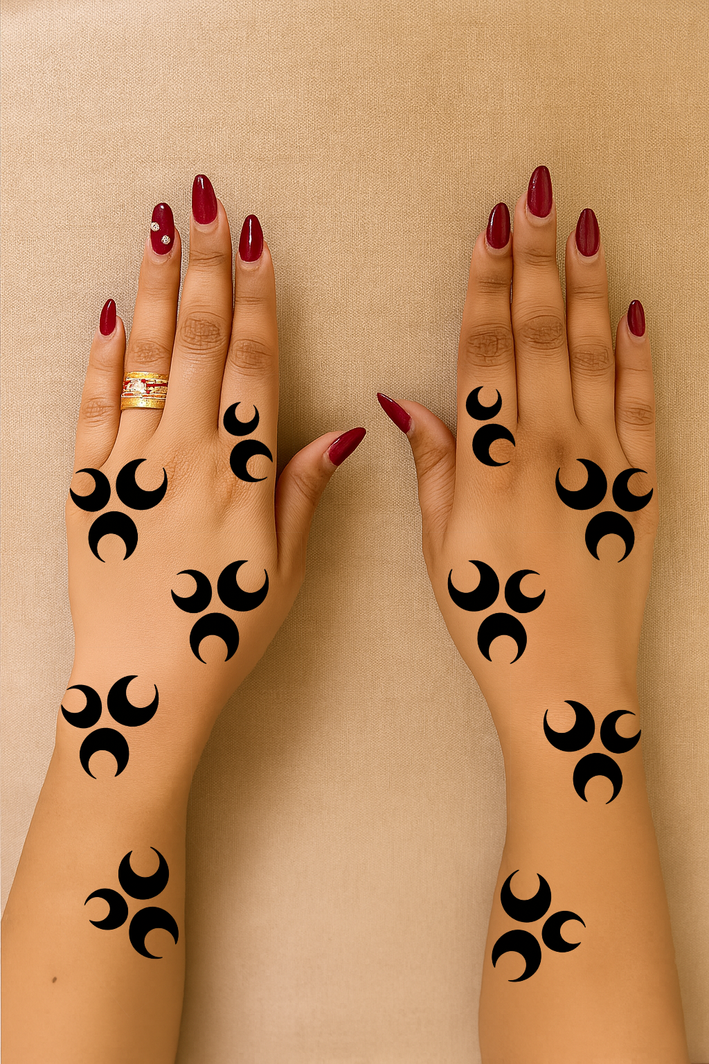 Two hands with crescent moon henna stencil design arranged in a minimal tribal pattern on fingers and wrists
