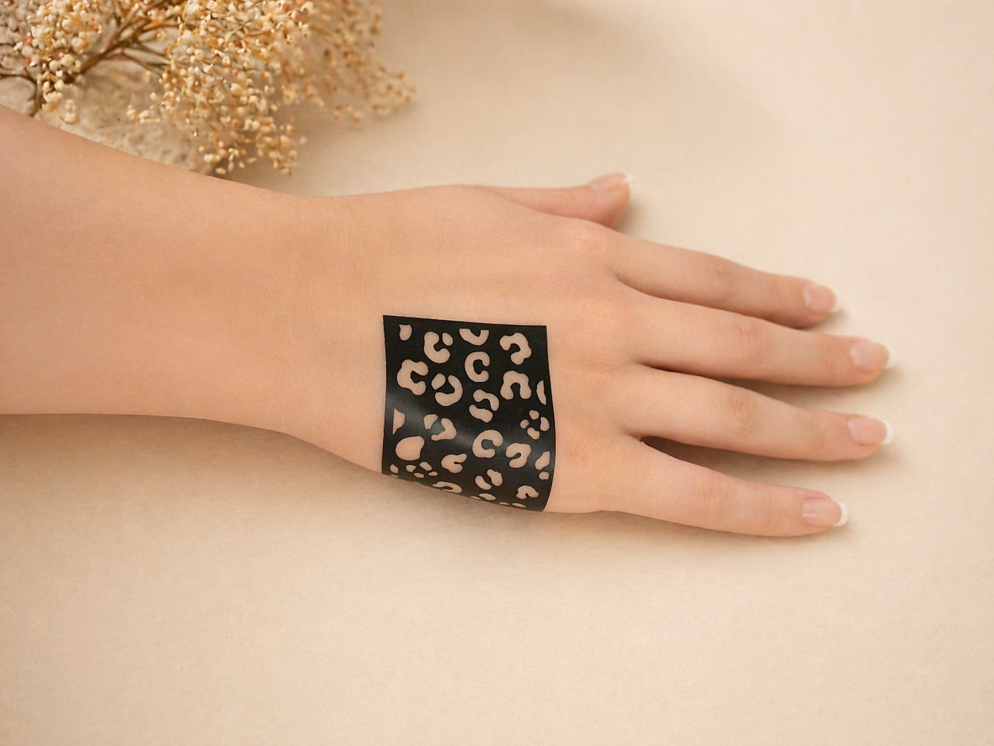 Close-up of a hand featuring black leopard print henna designs inspired by cheetah spots, creating a bold animal pattern mehndi look.